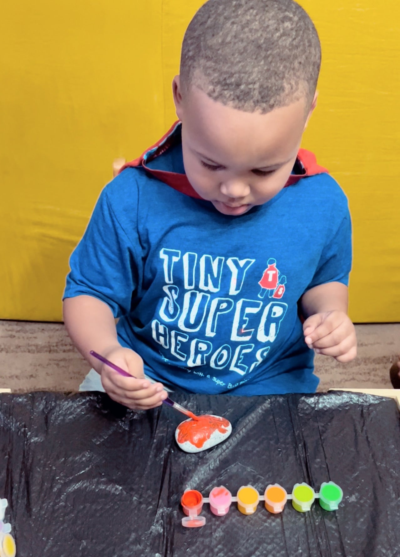 Super Kaz painting his kindness rocks