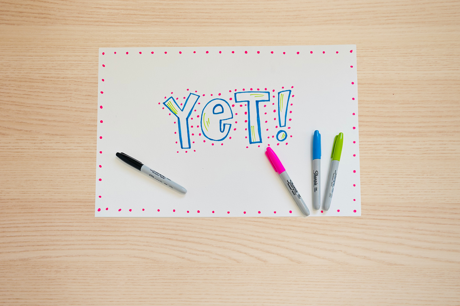 Photo of a poster with 'YET' written in the middle and markers around it.