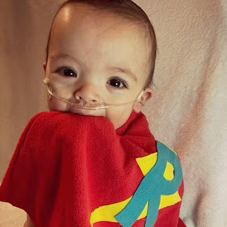 Girl standing showing off her red TinySuperheroes Cape